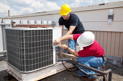 Two service technicians working on commercial HVAC equipment